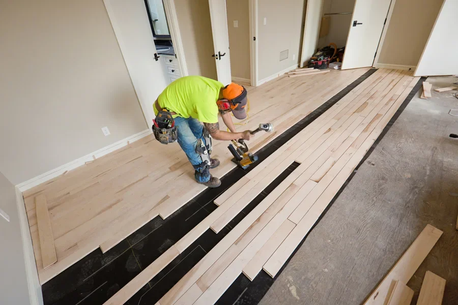 A-workman-installing-a-maple-hardwood-floor Pemanfaatan Sumber Daya Alam Indonesia untuk Pembangunan Properti Berkelanjutan